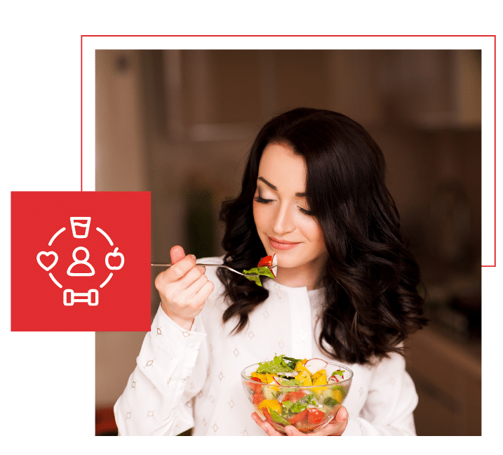 Woman eating a fresh salad at home with wellness icon next to her
