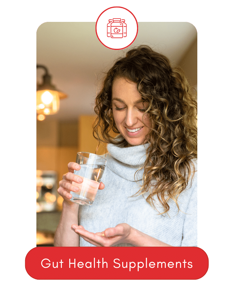 Smiling woman holding a glass of water and gut health supplements.