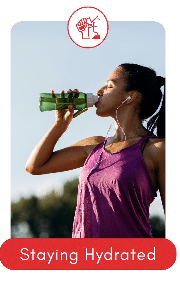 Woman drinking water from a bottle outdoors while wearing workout gear.