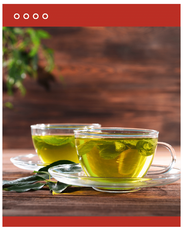 Two glass cups of green tea on a rustic table, symbolizing detox and metabolism support.
