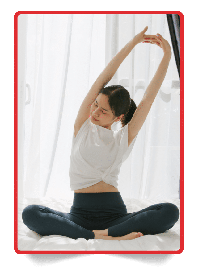 Woman stretching with arms raised during a morning routine, representing movement in a complete wellness checklist.